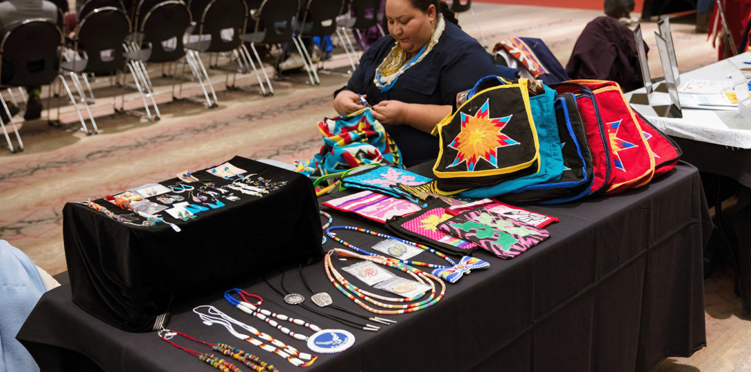 Woman at crafting table at 2019 Powwow